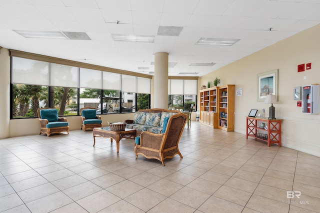 living room featuring light tile patterned floors and a paneled ceiling