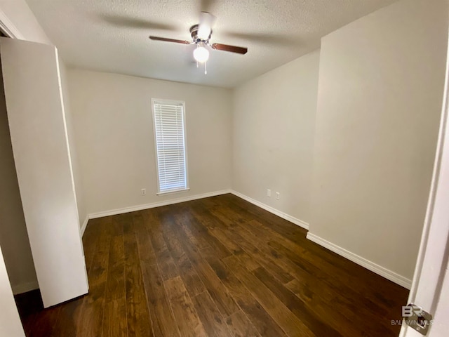 spare room featuring dark hardwood / wood-style flooring, ceiling fan, and a textured ceiling