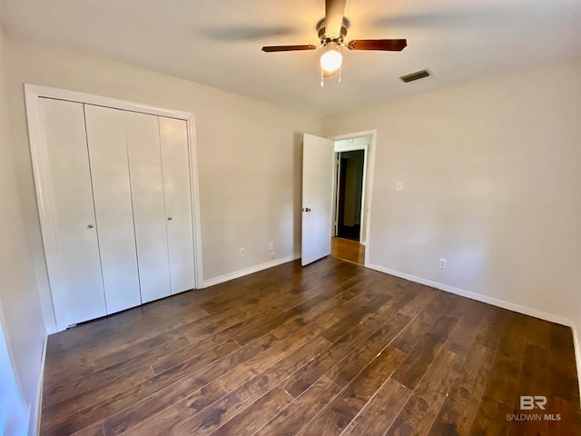 unfurnished bedroom with a closet, ceiling fan, and dark hardwood / wood-style flooring