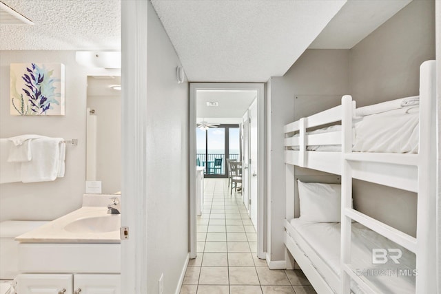 bathroom featuring baseboards, a textured ceiling, vanity, and tile patterned floors