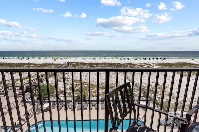 balcony with a water view and a view of the beach