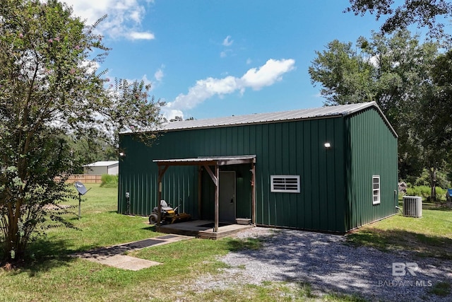 view of outbuilding with central air condition unit and a lawn