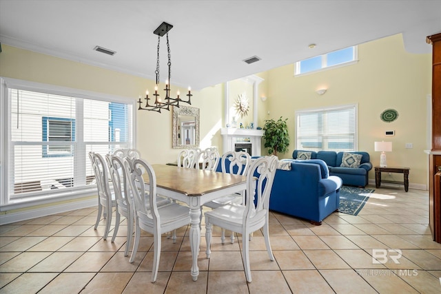 dining room featuring visible vents, a fireplace, light tile patterned flooring, and a healthy amount of sunlight