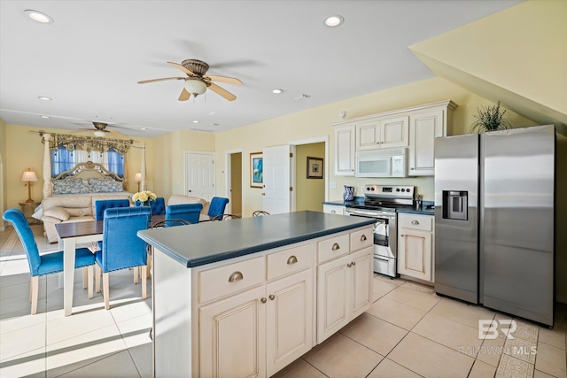 kitchen featuring dark countertops, open floor plan, a center island, stainless steel appliances, and recessed lighting