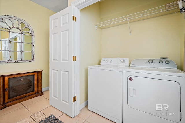 washroom featuring laundry area, light tile patterned floors, baseboards, and separate washer and dryer