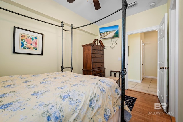 bedroom with ceiling fan, light wood finished floors, and visible vents