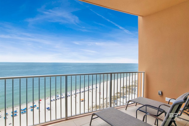 balcony featuring a view of the beach and a water view