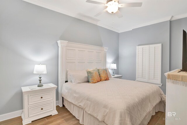 bedroom with light hardwood / wood-style floors, crown molding, and ceiling fan