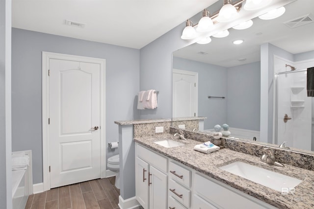 full bathroom with plus walk in shower, hardwood / wood-style floors, vanity, and toilet