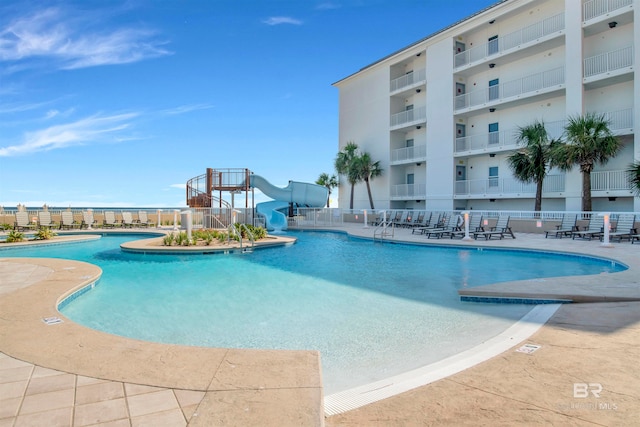 view of pool featuring a water slide and a patio area