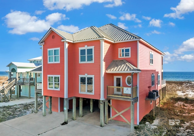 view of front facade featuring a carport, concrete driveway, stairs, and a water view