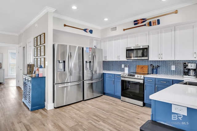 kitchen featuring crown molding, blue cabinetry, visible vents, and appliances with stainless steel finishes