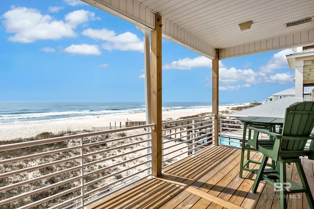 deck featuring a view of the beach and a water view