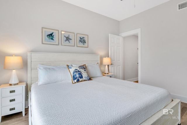 bedroom featuring visible vents, baseboards, and wood finished floors