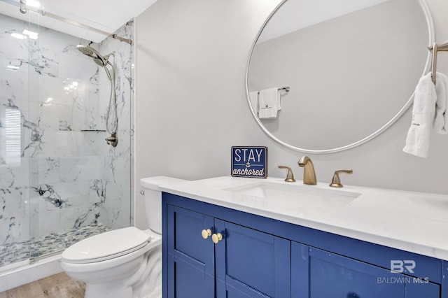 full bath with a marble finish shower, toilet, vanity, and wood finished floors