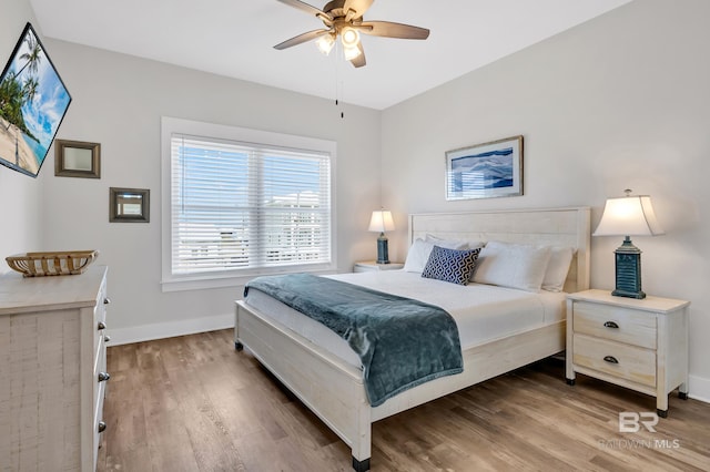 bedroom featuring a ceiling fan, baseboards, and wood finished floors