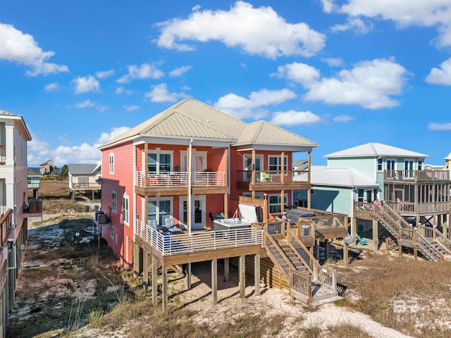 rear view of house featuring metal roof and a balcony