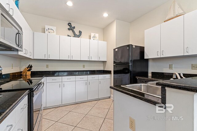 4615 Nancy Ln Unit 8, Orange Beach, AL 36561 - kitchen featuring light tile patterned flooring, sink, black fridge, range with electric stovetop, and white cabinets