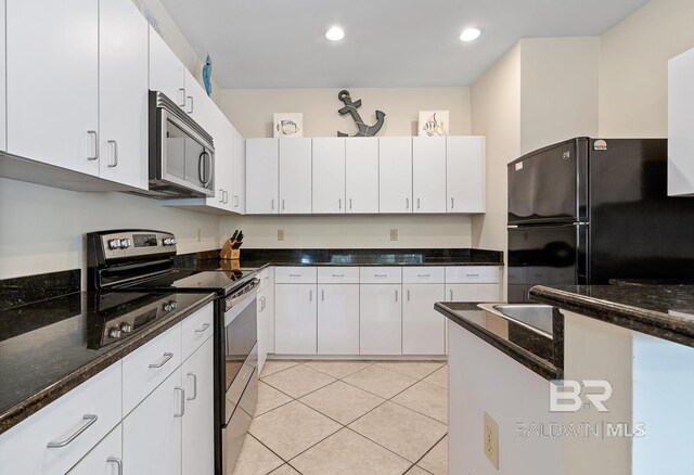 4615 Nancy Ln Unit 8, Orange Beach, AL 36561 - kitchen featuring white cabinetry, light tile patterned floors, stainless steel appliances, and dark stone countertops