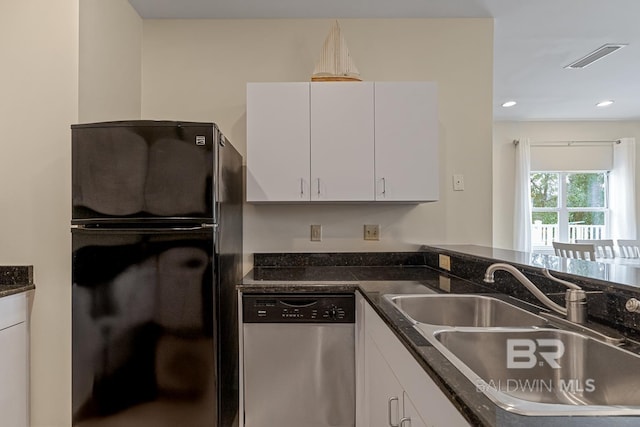4615 Nancy Ln Unit 8, Orange Beach, AL 36561 - kitchen with sink, white cabinetry, black fridge, stainless steel dishwasher, and dark stone counters