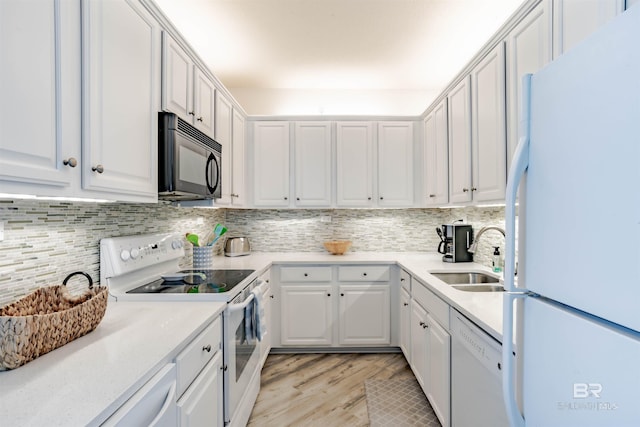 kitchen with white cabinets, white appliances, sink, and tasteful backsplash