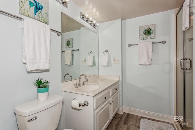 bathroom with toilet, a shower with door, vanity, and hardwood / wood-style flooring