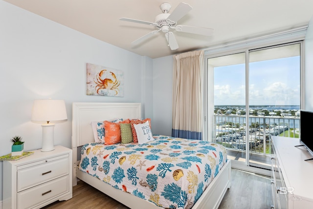 bedroom with access to exterior, hardwood / wood-style flooring, and multiple windows