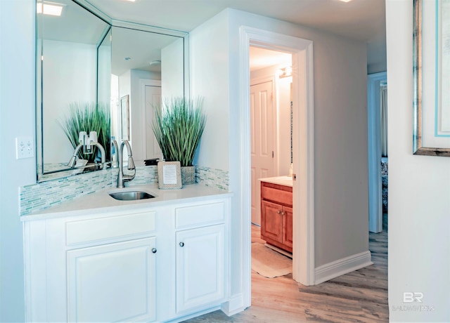 bathroom featuring hardwood / wood-style floors, vanity, and decorative backsplash