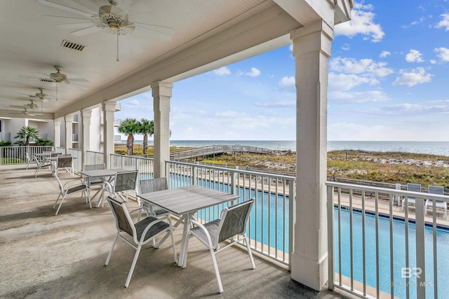 balcony featuring a water view and ceiling fan