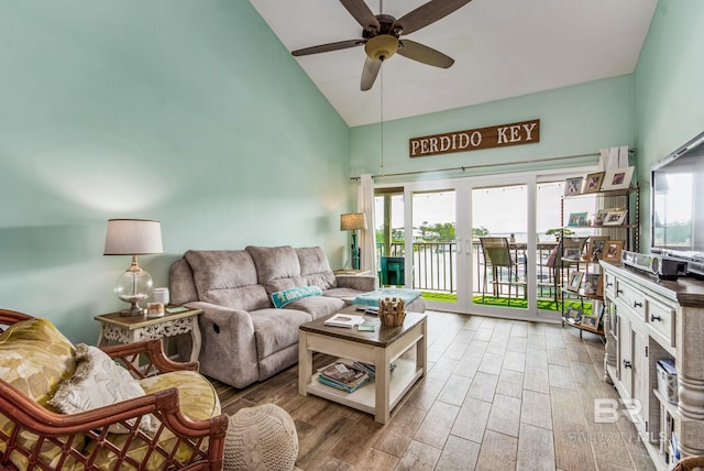 living room featuring high vaulted ceiling, ceiling fan, light wood-type flooring, and plenty of natural light