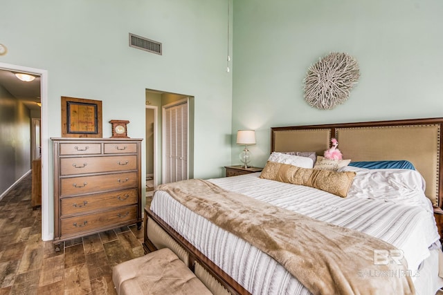 bedroom featuring a high ceiling and dark hardwood / wood-style floors