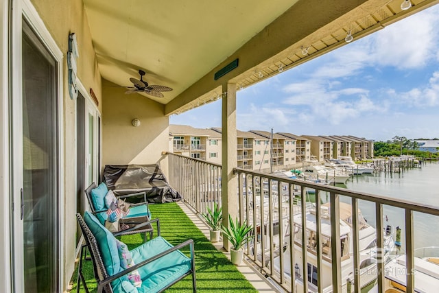 balcony with a water view and ceiling fan