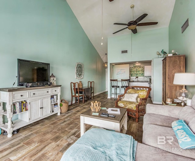 living room with hardwood / wood-style flooring, high vaulted ceiling, and ceiling fan