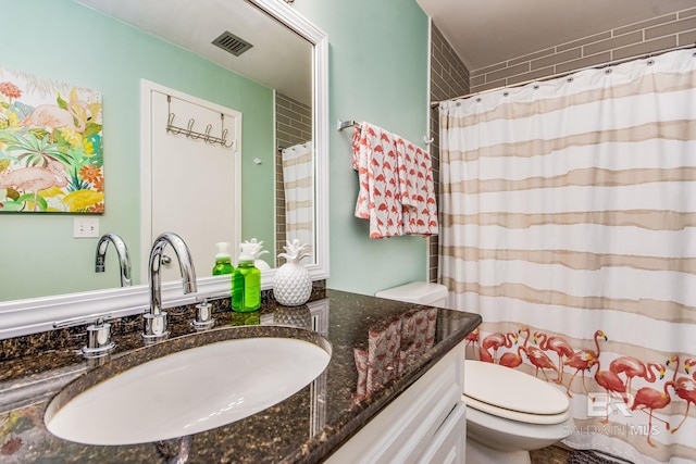 bathroom featuring toilet and vanity with extensive cabinet space