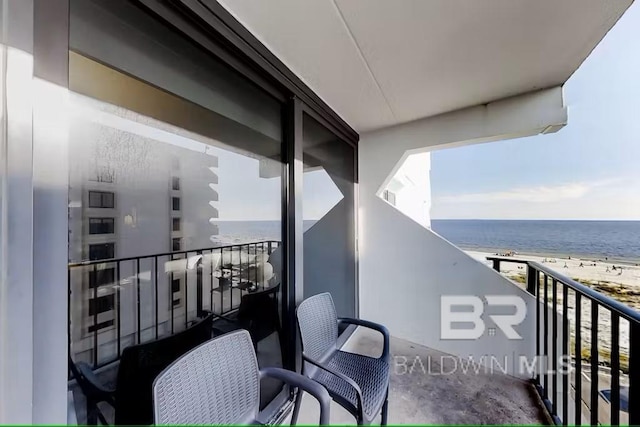 balcony with a water view and a view of the beach