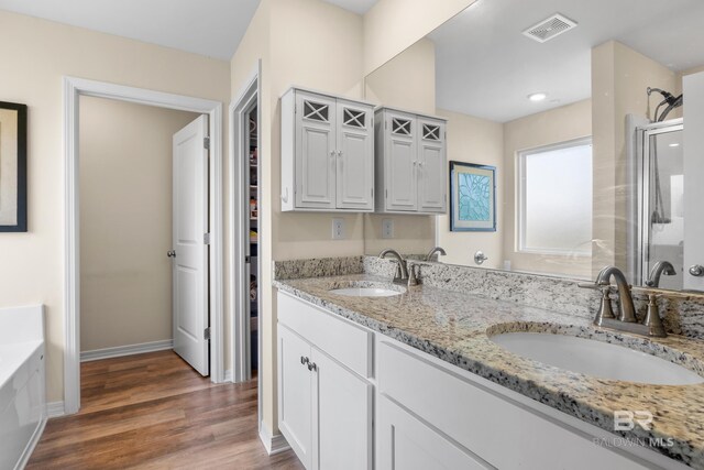 bathroom featuring hardwood / wood-style floors, vanity, and independent shower and bath