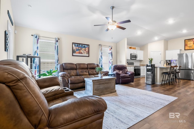 living room featuring ceiling fan, sink, dark wood-type flooring, and vaulted ceiling