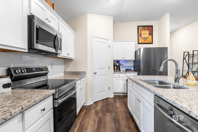 kitchen featuring white cabinets, appliances with stainless steel finishes, light stone countertops, and sink