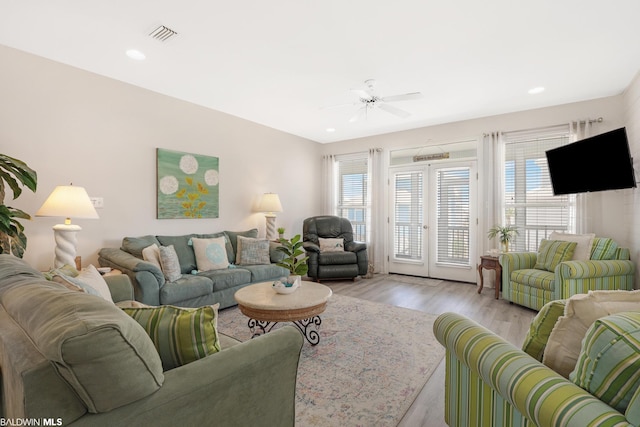 living room featuring light hardwood / wood-style flooring and ceiling fan