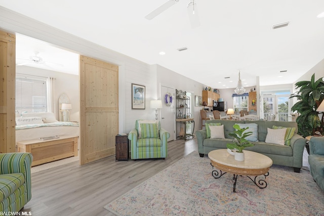 living room with ceiling fan and light hardwood / wood-style flooring