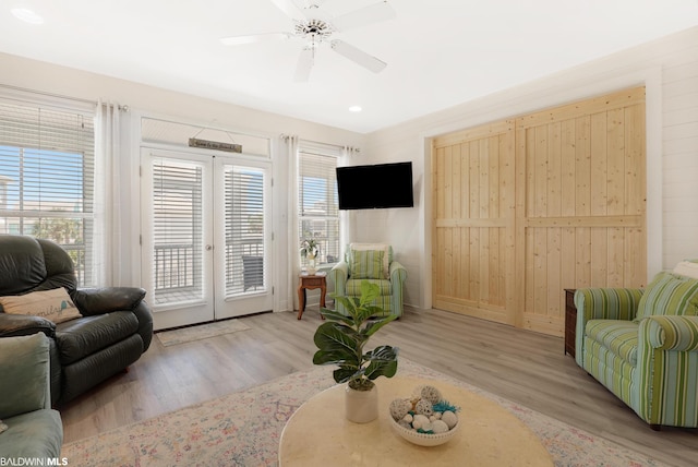 living room featuring french doors, light hardwood / wood-style floors, and ceiling fan