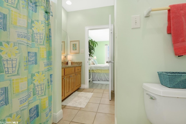 bathroom featuring tile flooring, toilet, and vanity
