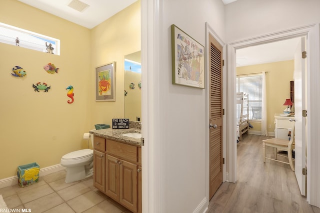 bathroom featuring toilet, vanity, and wood-type flooring