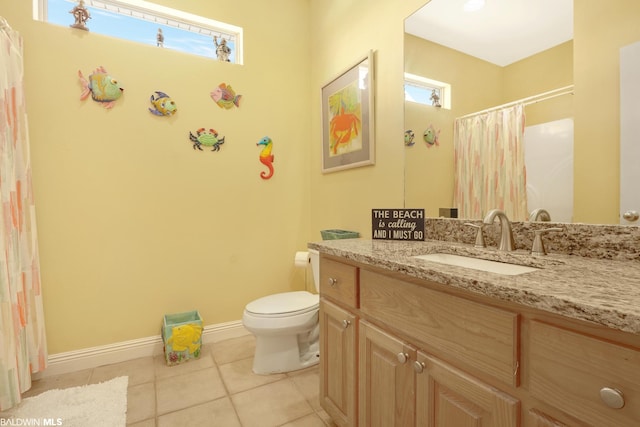 bathroom with tile floors, toilet, vanity, and a wealth of natural light