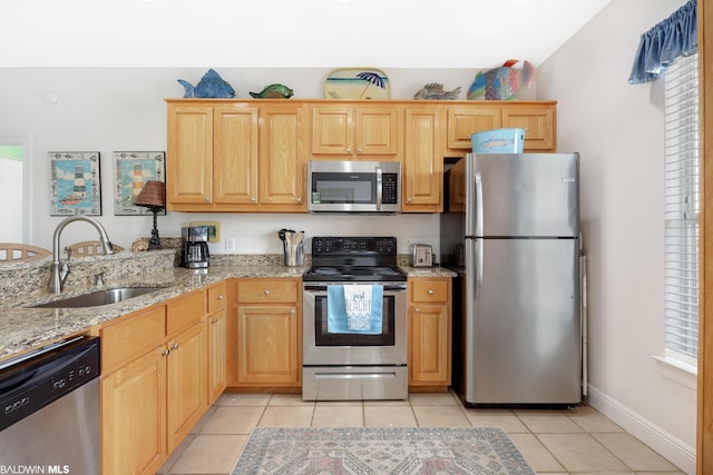 kitchen with light tile flooring, stainless steel appliances, a healthy amount of sunlight, and sink