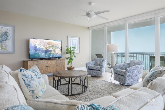 tiled living room with ceiling fan and expansive windows