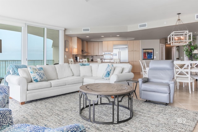 living room featuring light tile patterned flooring and a notable chandelier