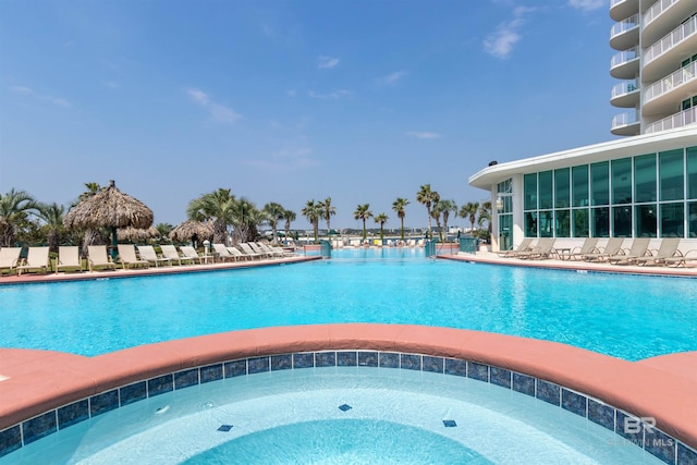 view of swimming pool with a hot tub