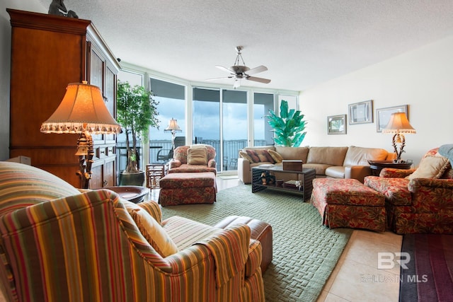 living room with floor to ceiling windows, ceiling fan, and a textured ceiling