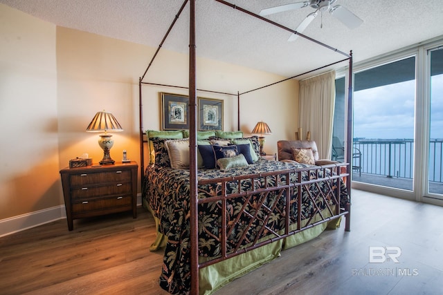 bedroom with access to outside, ceiling fan, floor to ceiling windows, wood-type flooring, and a textured ceiling